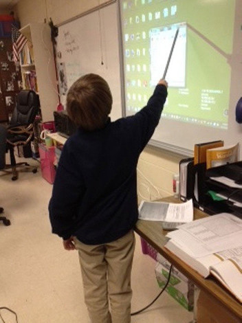 Student uses interactive whiteboard to share information with others.